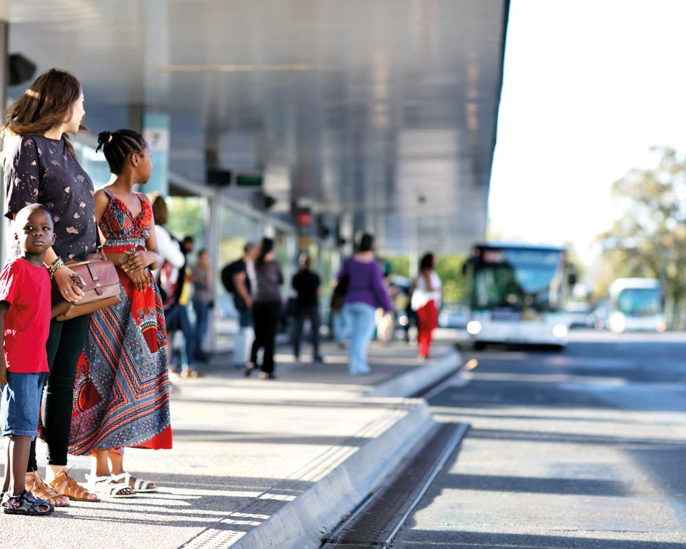 Femme qui attend le bus avec deux enfants